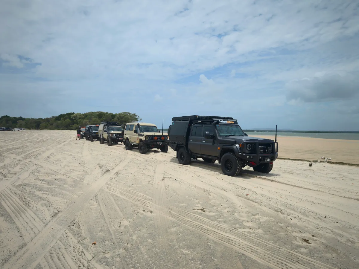 Lineup of touring 4x4 vehicles on a sandy beach